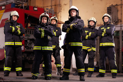 Portrait of firefighters standing in fire station