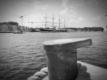 Sailboats moored at harbor against sky