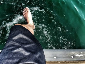 Low section of man sitting in swimming pool