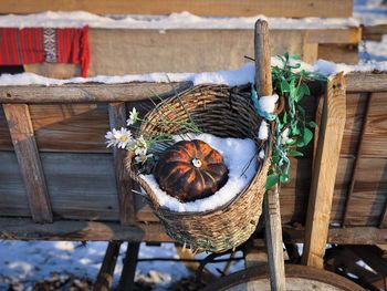 Decorative basket made of twigs filled with pumpkins covered in snow