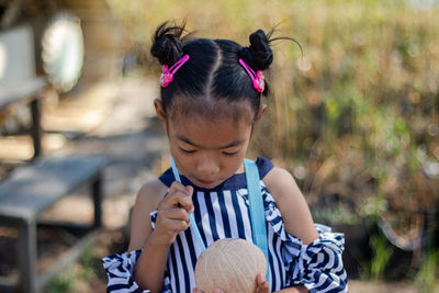 Close-up of cute girl drinking coconut