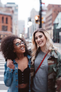 Cheerful friends crossing road in city