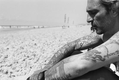 Side view of man on beach against sky