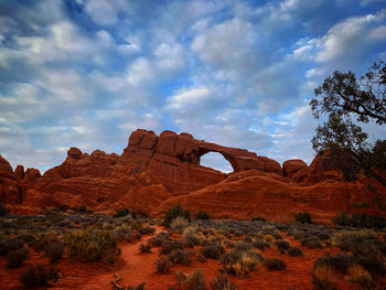 Rock formations on landscape against cloudy sky