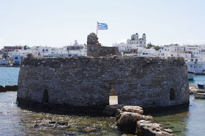 Built structure by sea against clear sky