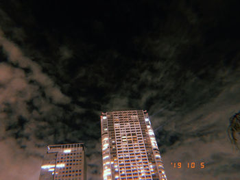 Low angle view of illuminated buildings against sky at night