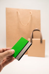 Cropped hand of woman using mobile phone against white background