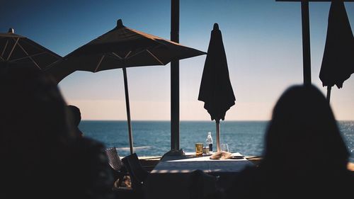 People relaxing at outdoor cafe by beach