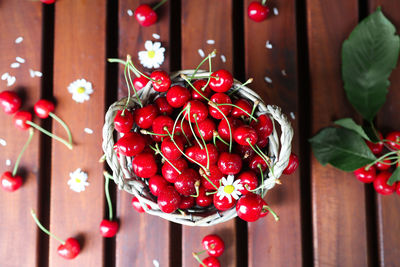 Ripe cherry with chamomile flowers on a wooden background top view. harvest fruits on the table 