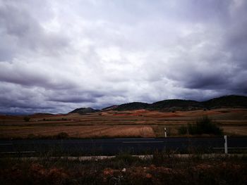 Scenic view of field against cloudy sky