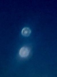 Low angle view of moon against blue sky