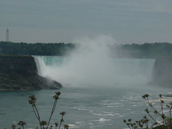 Scenic view of waterfall against sky
