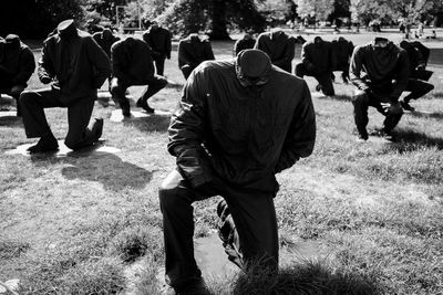 Group of people kneel down on field