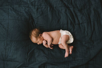 High angle view of baby sleeping on bed