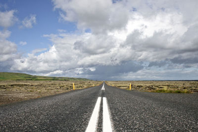 Empty road against cloudy sky