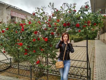 Portrait of smiling woman standing against plants