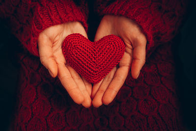 Female hand holding red knitted heart. organ donation, family insurance. love concept