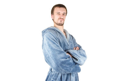 Portrait of young man standing against white background