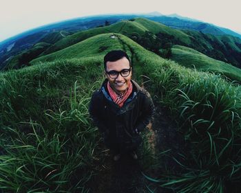 Portrait of smiling young man standing on mountain