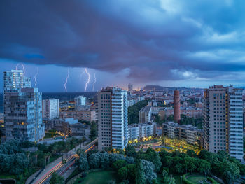 Buildings in city against cloudy sky