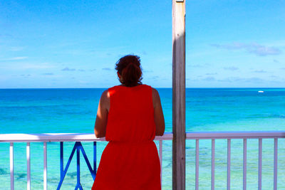 Rear view of woman looking at sea against sky