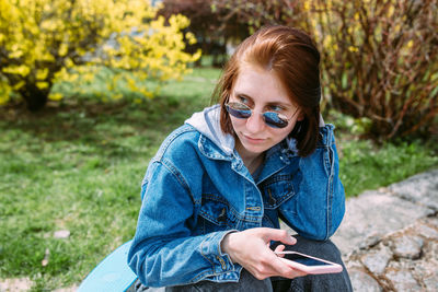 Portrait of young woman sitting on field