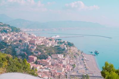 High angle view of townscape by sea against sky