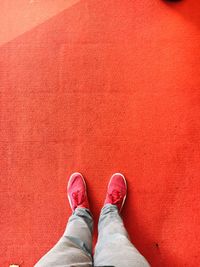 Low section of man standing on red surface