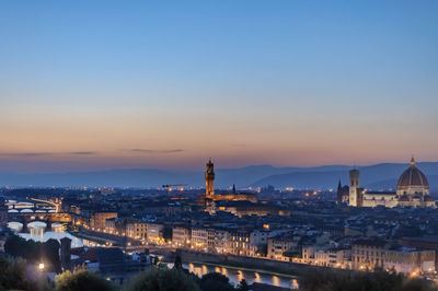 High angle view of city lit up at sunset