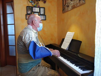 Side view of man playing piano