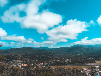 Aerial view of city by mountain against sky