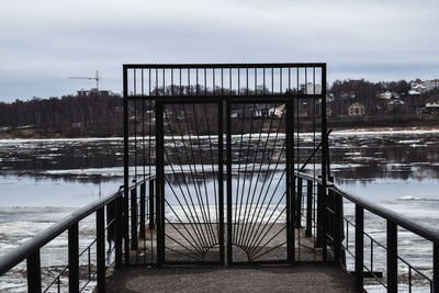 Bridge over lake against sky during winter