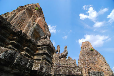 Low angle view of statue of historic building against sky