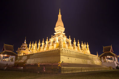 Illuminated buildings in city against sky at night