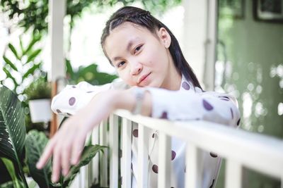 Portrait of cute girl looking at railing