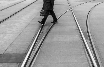 Low section of man walking on tramway