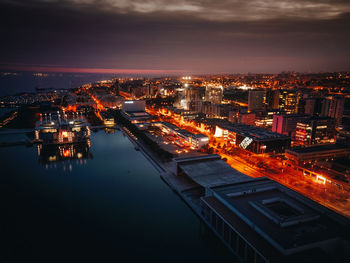 High angle view of illuminated cityscape against sky at night