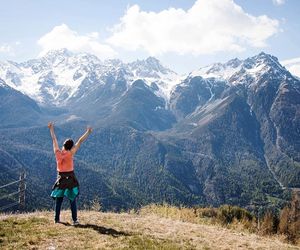 Woman with spread arms looking at mountain landscape