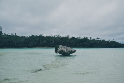 Scenic view of rocks on sea against sky