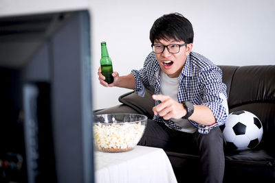 Man eating popcorn while watching tv