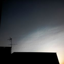 Low angle view of weather vane against sky