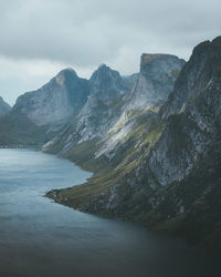 Scenic view of mountains and lake against sky during foggy weather