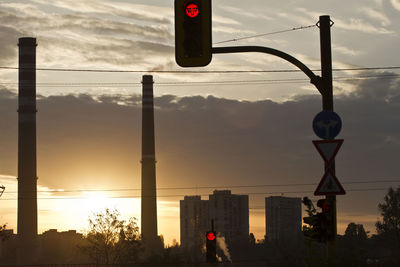 Low angle view of street light against buildings at sunset