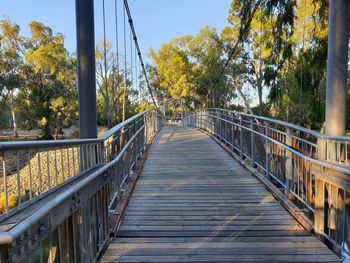 Empty footbridge along plants