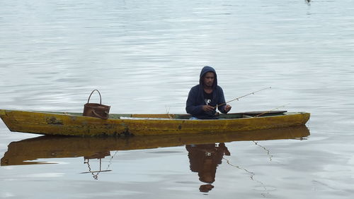 Man sitting on a boat on the kapuas river while fishing