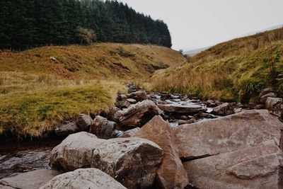 Rocks on landscape against sky