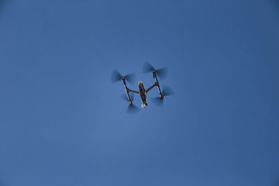 Low angle view of drone flying in clear sky