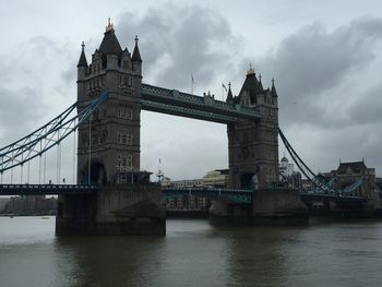 Bridge over river against cloudy sky