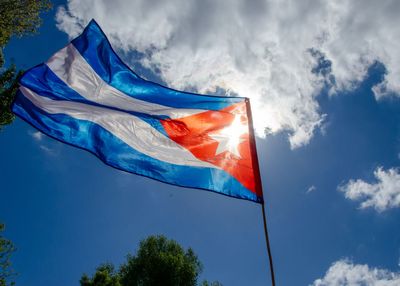 Low angle view of flag against blue sky