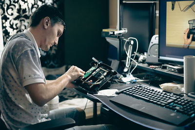 A young man repairs the engine steering wheel on a joystick.